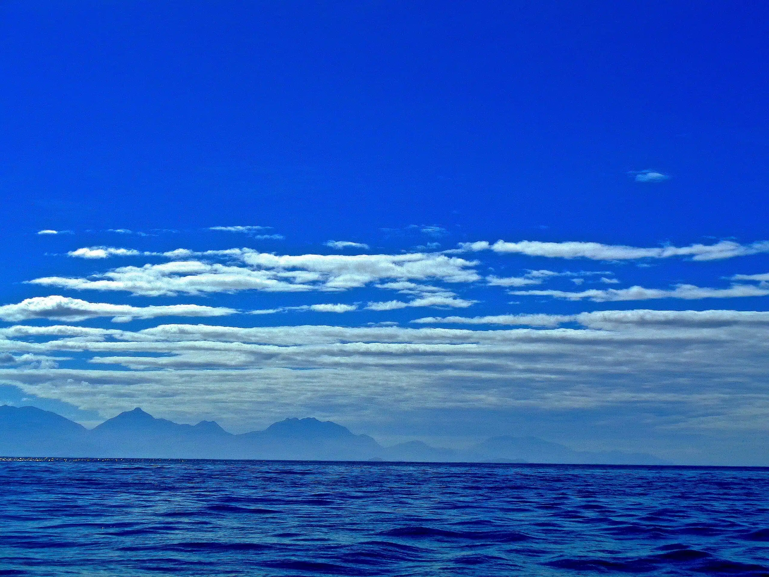 a large body of water with mountains in the background