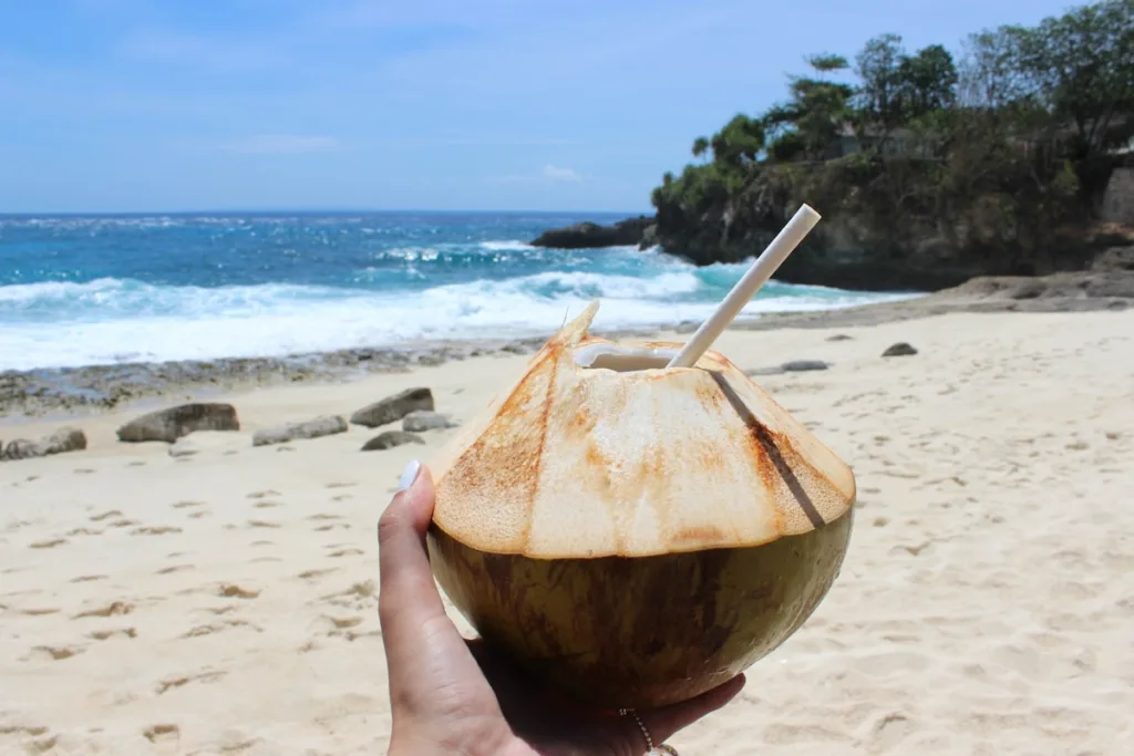Man drinking fresh coconut water on a beach in Salvador