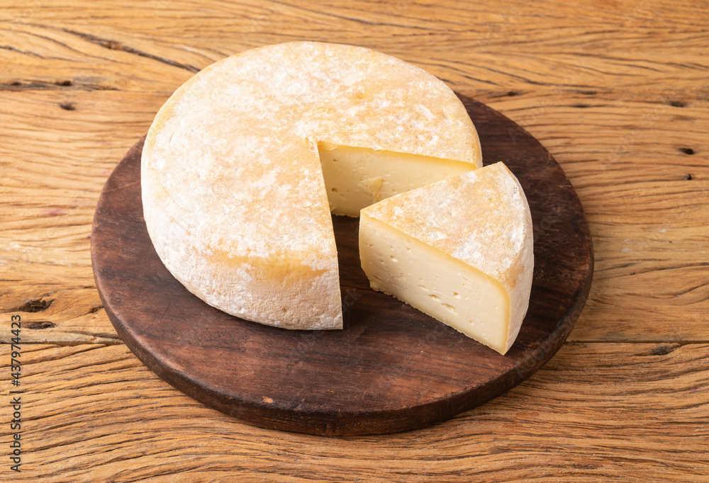 Artisanal Canastra cheese from Minas Gerais, Brazil over wooden board with cut piece