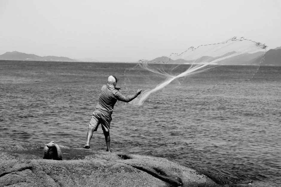 fisherman mending nets beach morning in Brazil